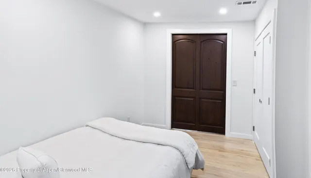 a bedroom with a bed and wooden floor