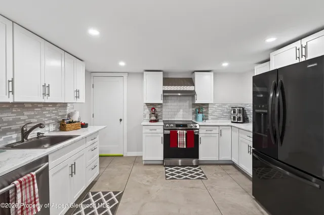 a kitchen with stainless steel appliances granite countertop a sink stove and cabinets