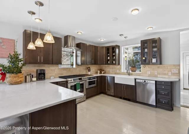 a kitchen with stainless steel appliances granite countertop a sink a stove and a refrigerator