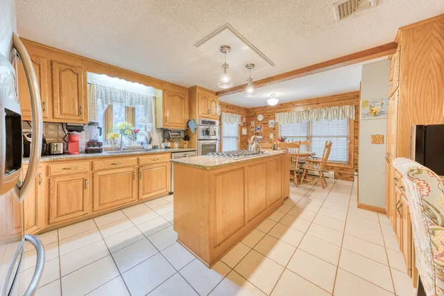 a large kitchen with a large counter top space a sink a counter space and appliances