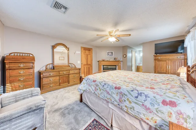 a spacious bedroom with a bed and dresser