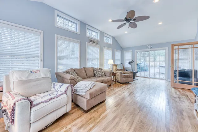 a living room with furniture ceiling fan and a wooden floor