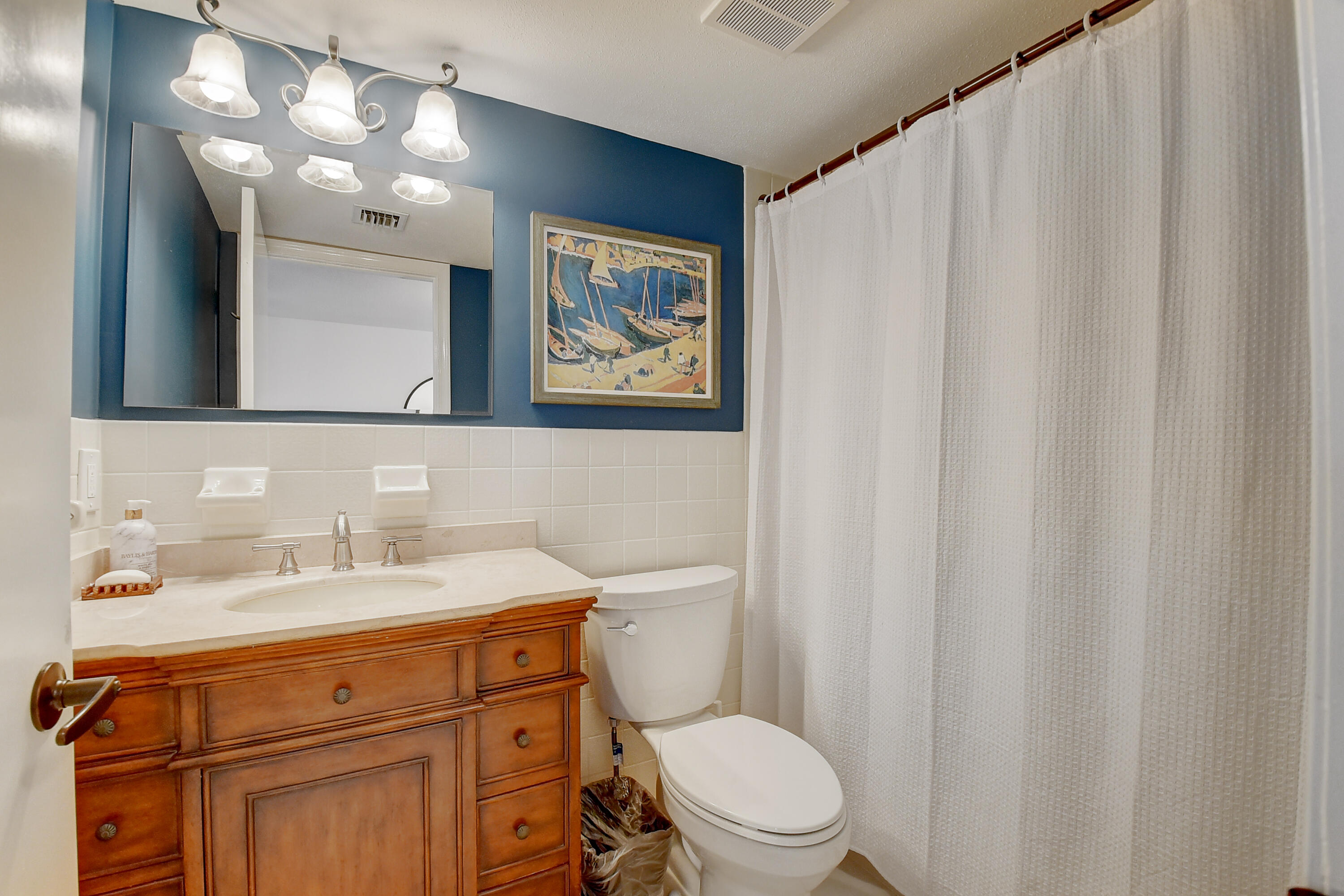 399 Southwest 15th Street Boca Raton, FL 33432 - Photo 27 of 49 a bathroom with a toilet a sink a vanity and mirror