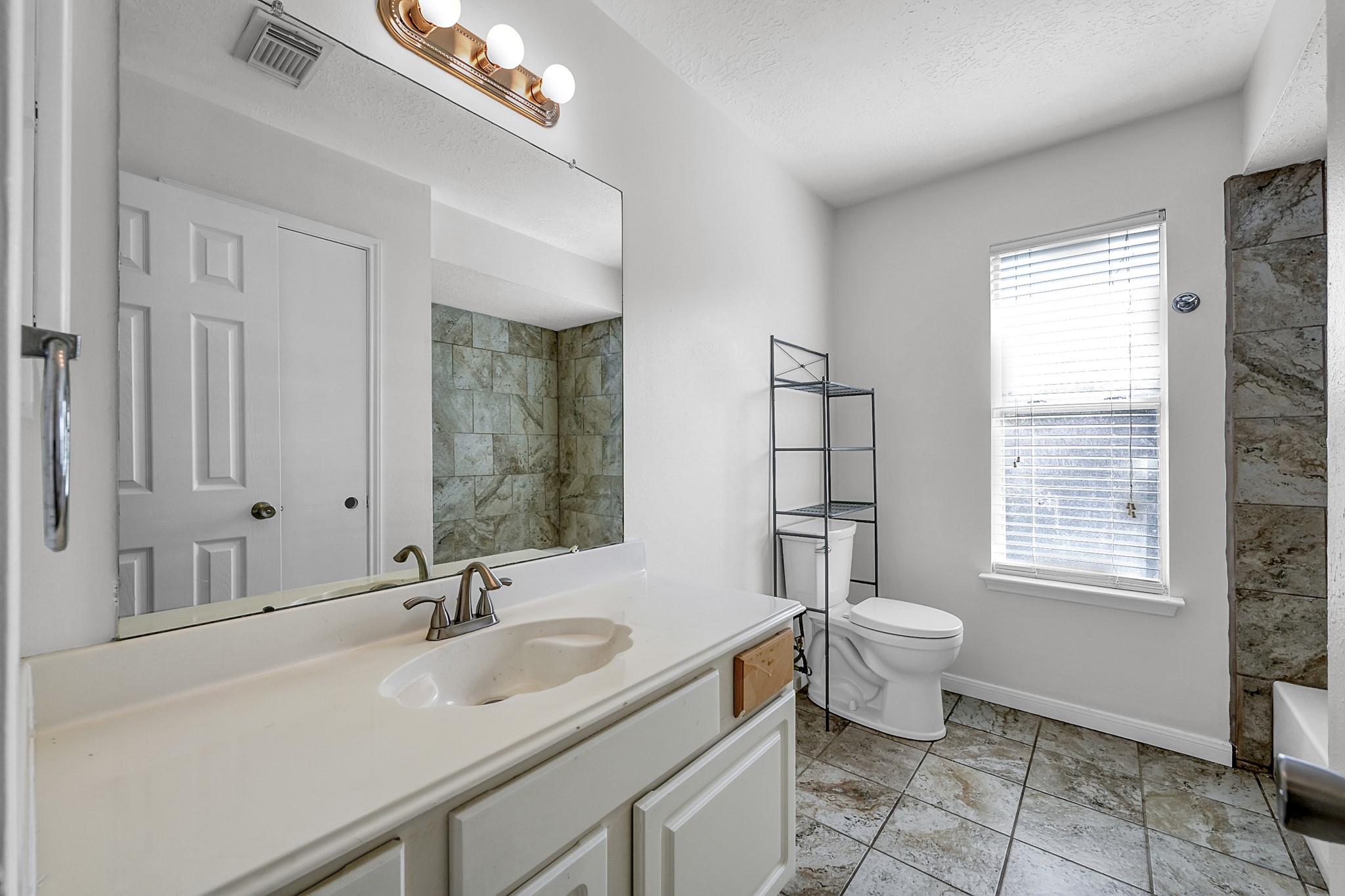 30818 Trinket Drive Spring, TX 77386 - Photo 26 of 29 a bathroom with a granite countertop toilet a sink and a mirror