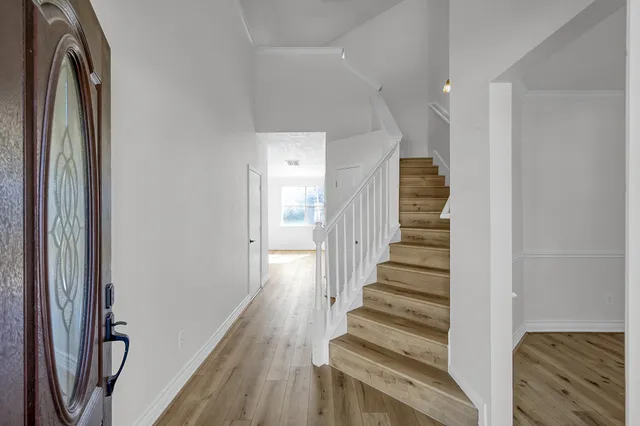 a view of a hallway with wooden floor and entryway