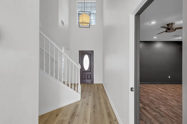 a view of a hallway with wooden floor and staircase