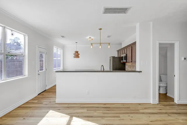 a view of a livingroom with wooden floor and staircase
