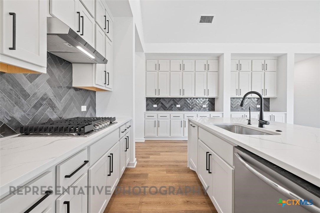 11925 Lofted Bloom Schertz, TX 78154 - Photo 4 of 12 a kitchen with stainless steel appliances granite countertop a sink stove and cabinets