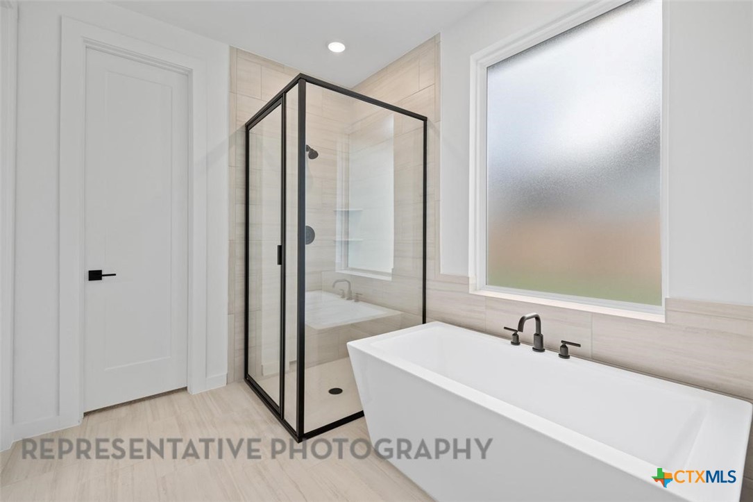 11925 Lofted Bloom Schertz, TX 78154 - Photo 6 of 12 a bathroom with a bathtub and a sink