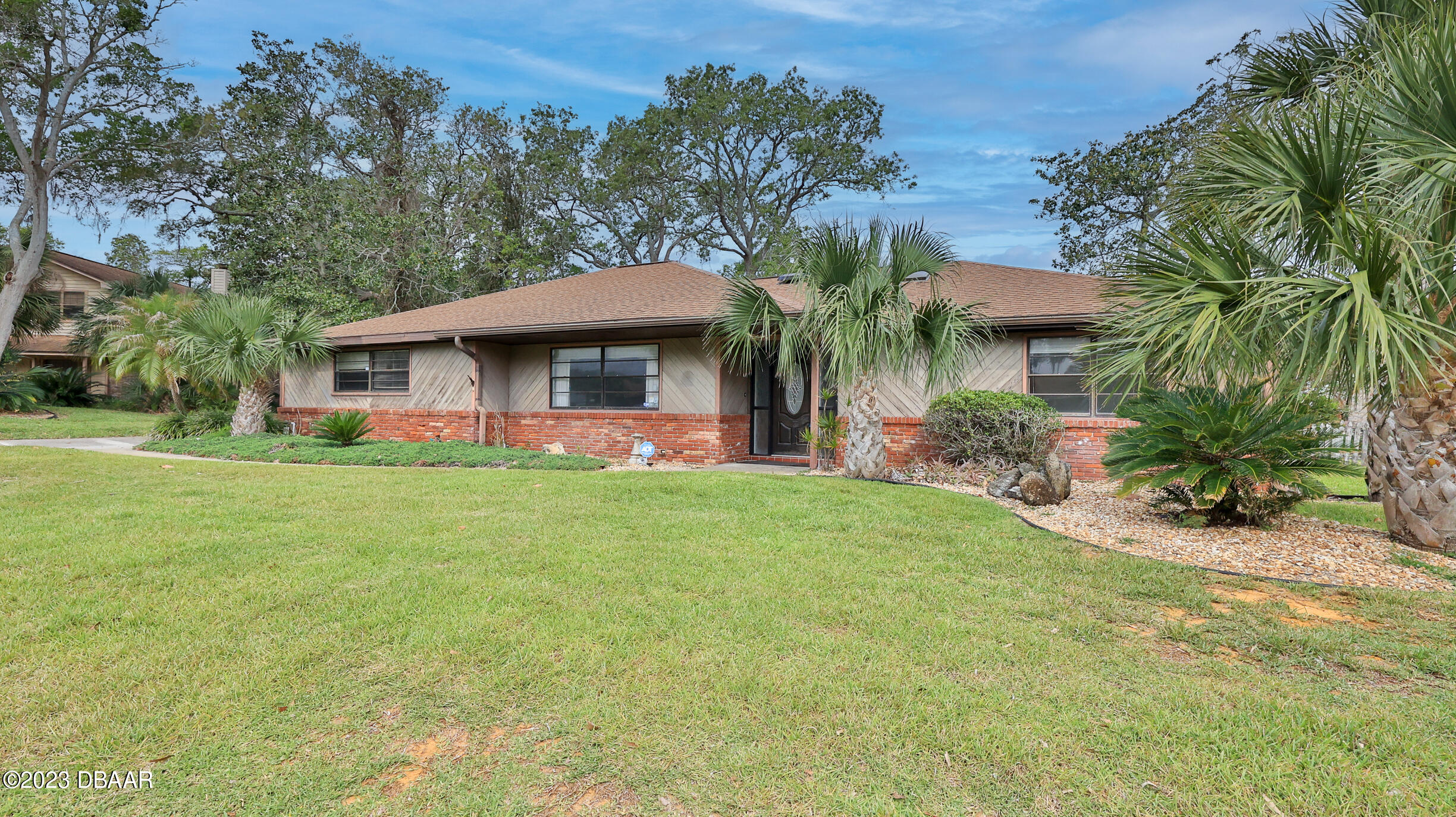 a view of a house with a yard patio and palm tree