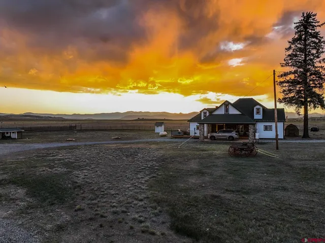 a view of house with backyard and trees