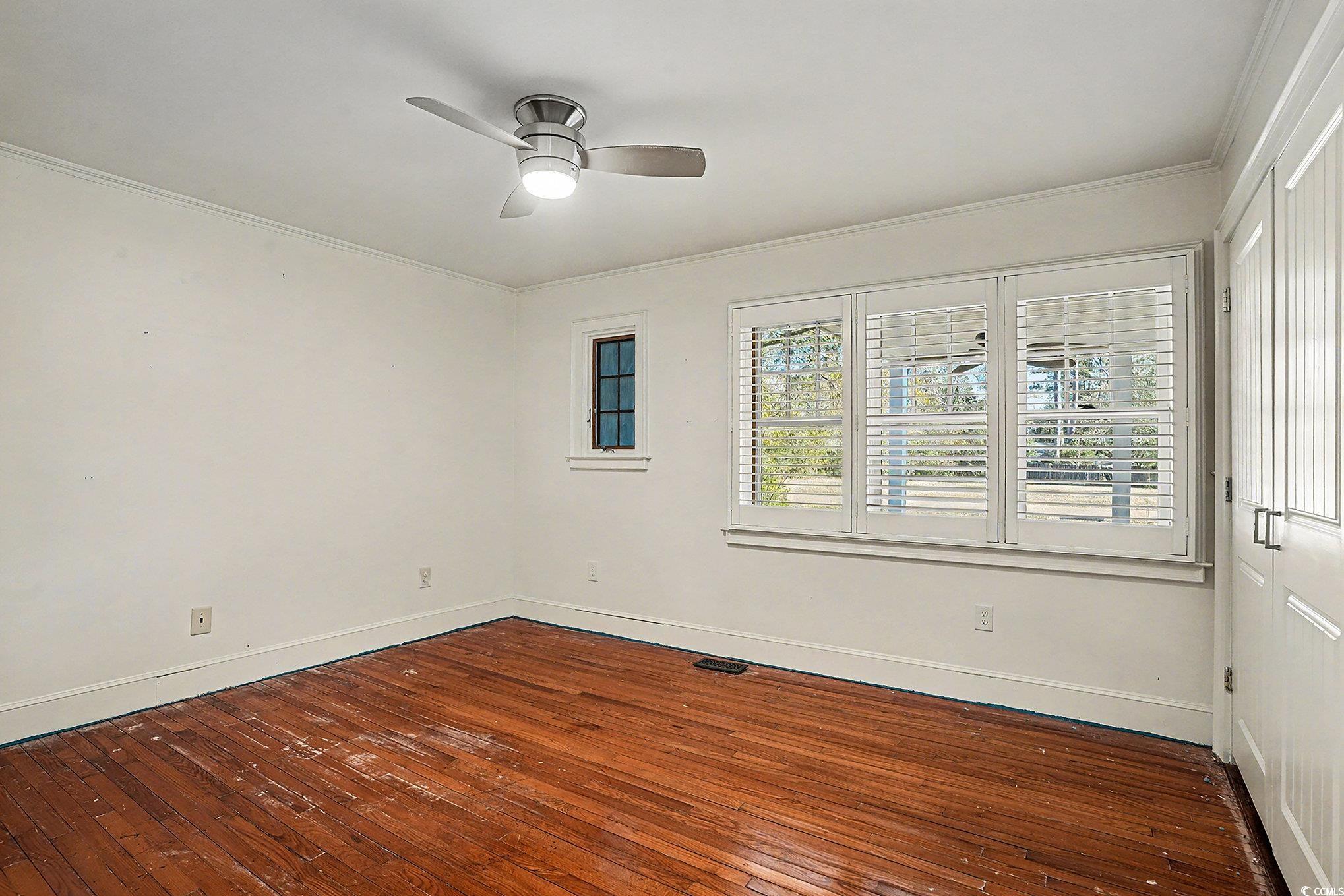 218 Busbee Street Conway, SC 29526 - Photo 14 of 30 Unfurnished room featuring dark wood-type flooring, a ceiling fan, and crown molding
