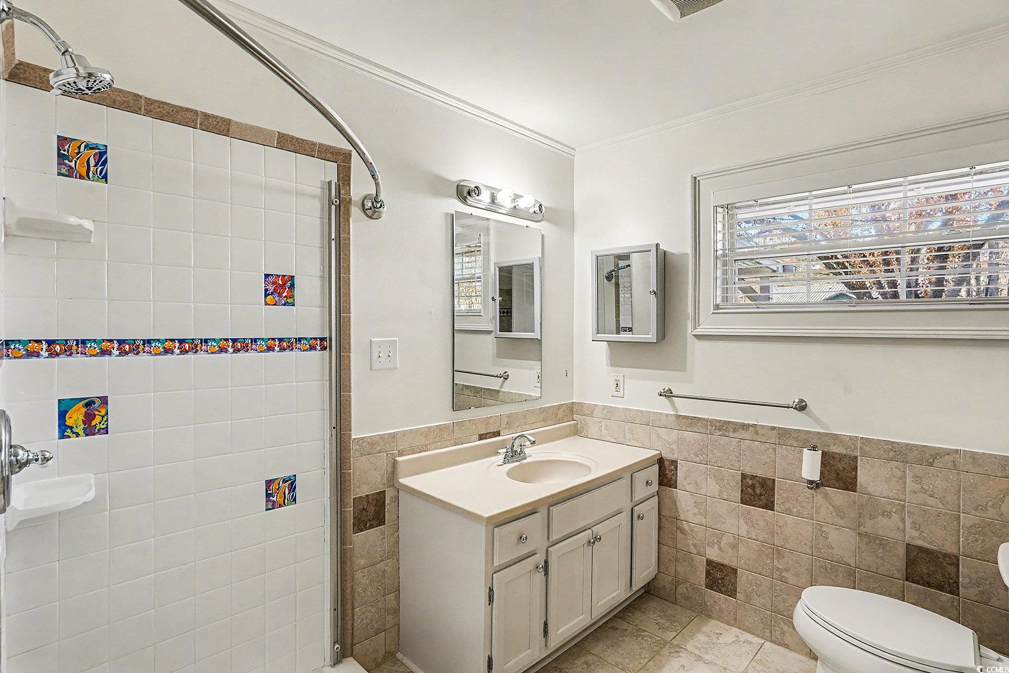 218 Busbee Street Conway, SC 29526 - Photo 16 of 30 Bathroom with tile walls, a shower stall, wainscoting, vanity, and ornamental molding