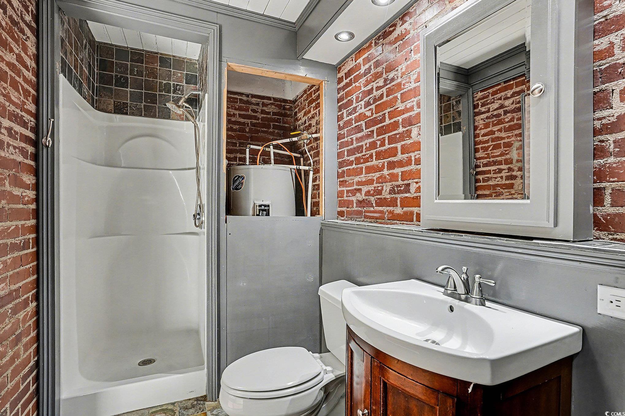 218 Busbee Street Conway, SC 29526 - Photo 20 of 30 Bathroom featuring brick wall, a stall shower, vanity, electric water heater, and recessed lighting