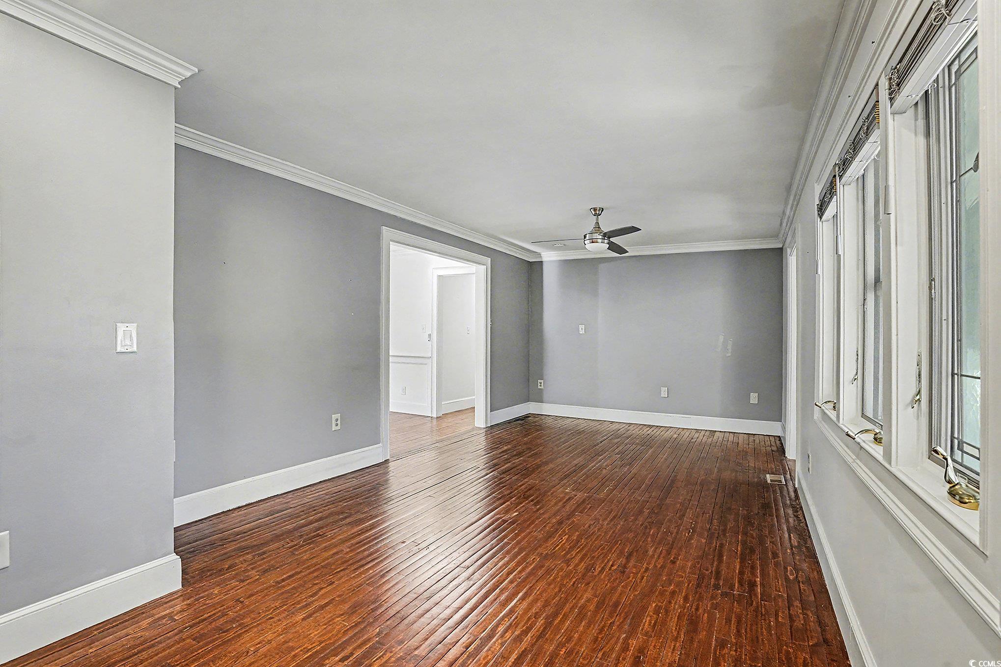 218 Busbee Street Conway, SC 29526 - Photo 7 of 30 Unfurnished room featuring ornamental molding, dark wood-style flooring, and ceiling fan