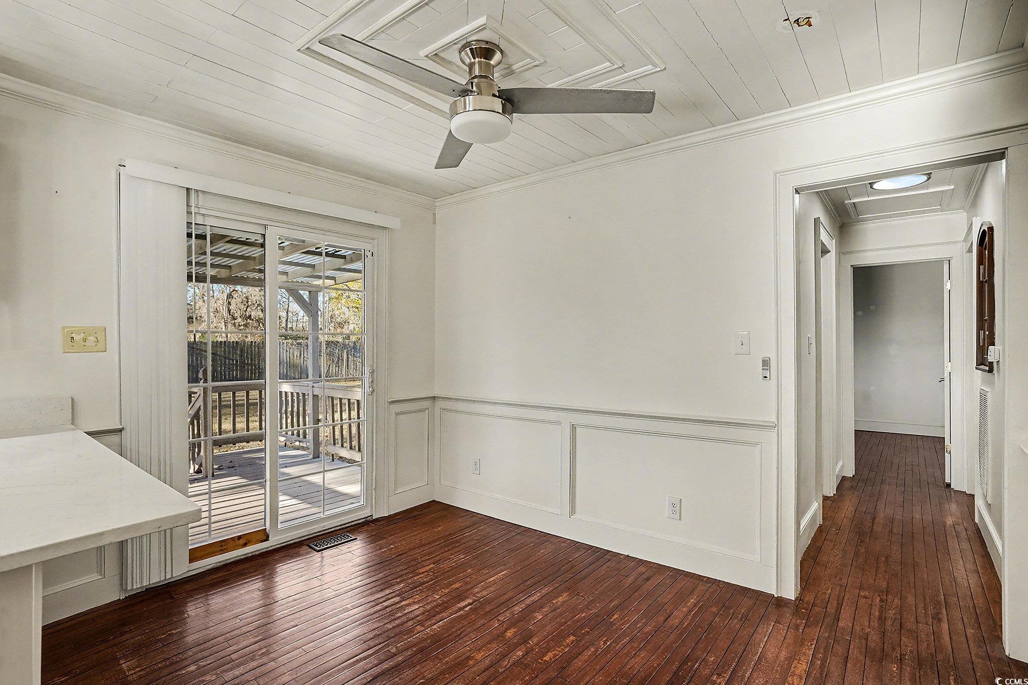 218 Busbee Street Conway, SC 29526 - Photo 9 of 30 Unfurnished dining area featuring wood ceiling, dark wood-type flooring, a decorative wall, a wainscoted wall, and ceiling fan