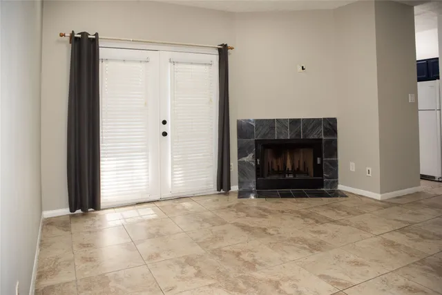a view of empty room with fireplace and fan