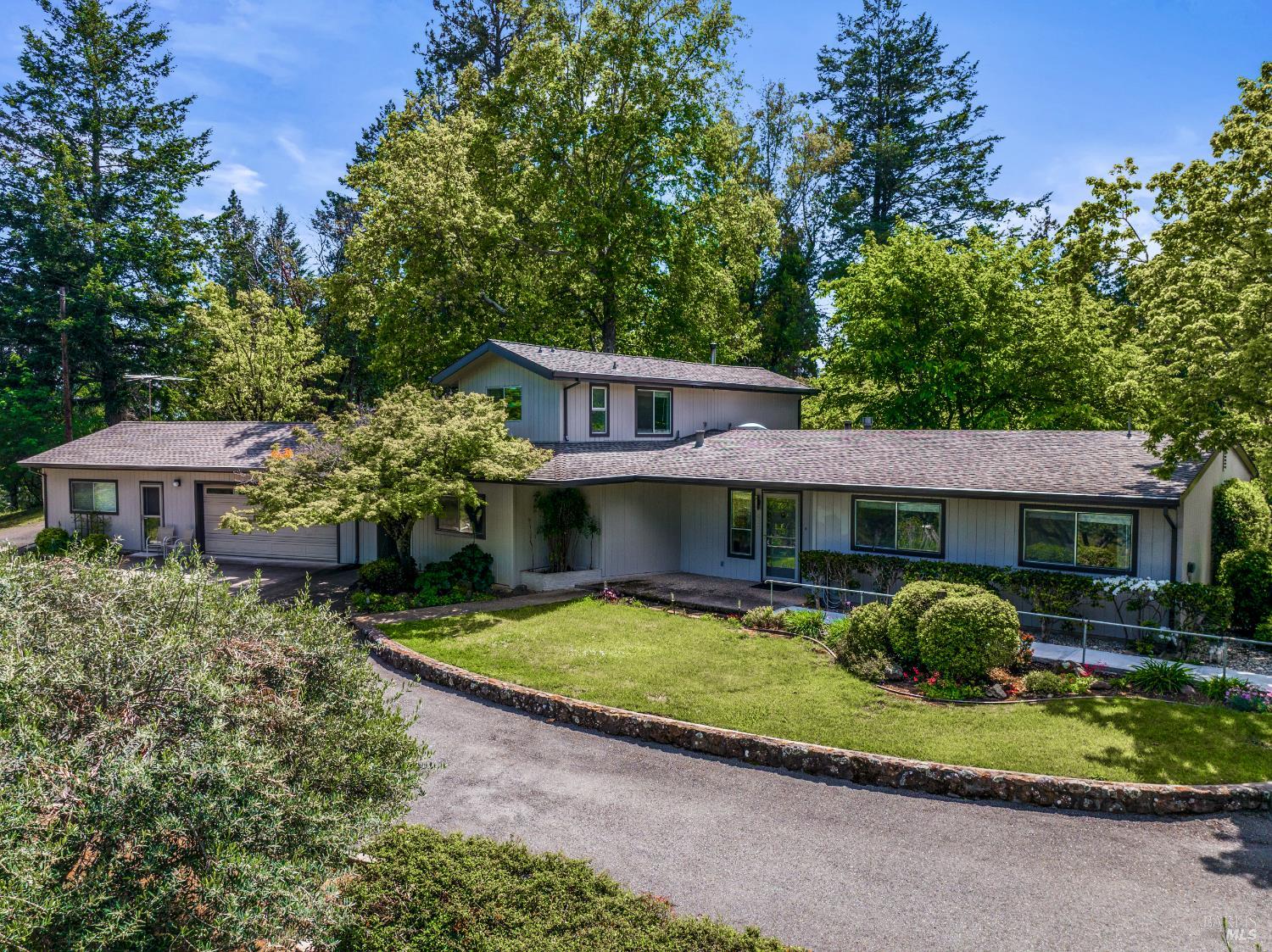 625-629 Hill Road Angwin, CA 94508 - Photo 2 of 64 a front view of a house with a yard garage and outdoor seating