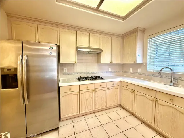 a kitchen with a refrigerator sink and cabinets