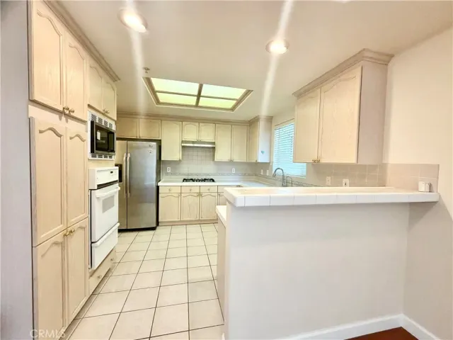 a kitchen with stainless steel appliances a refrigerator sink and cabinets