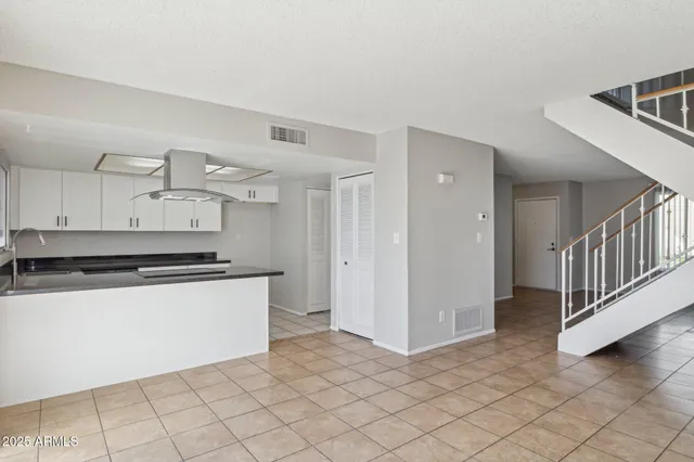 a kitchen with granite countertop a sink a stove and cabinets