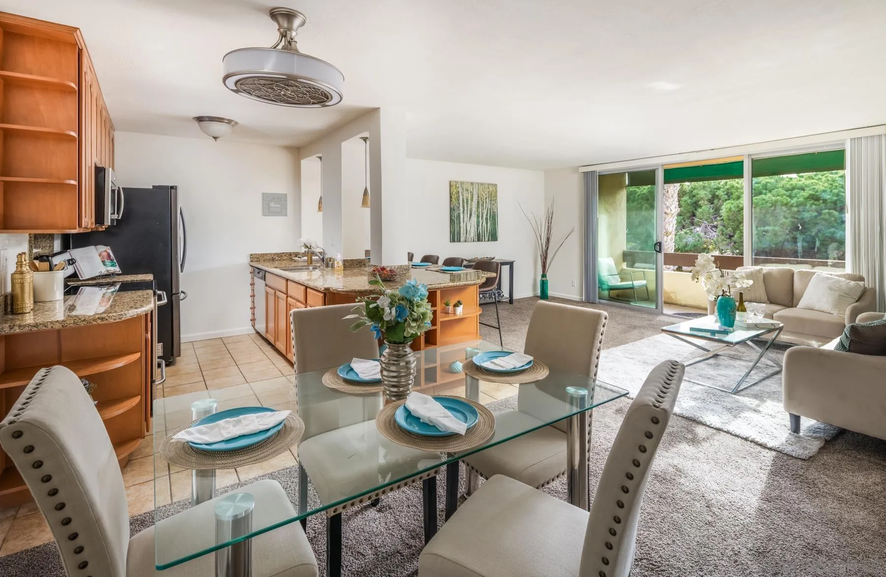 a view of a dining room with furniture a chandelier and large windows