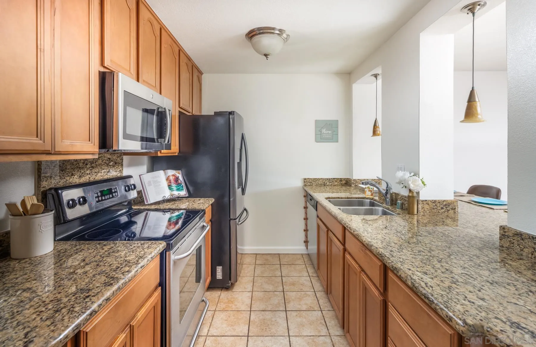 6455 La Jolla Boulevard, Unit 203 La Jolla, CA 92037 - Photo 9 of 21 a kitchen with stainless steel appliances granite countertop a sink stove and refrigerator