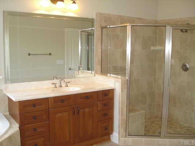 5308 Landguard Drive Raleigh, NC 27613 - Photo 8 of 12 a bathroom with a shower sink and mirror