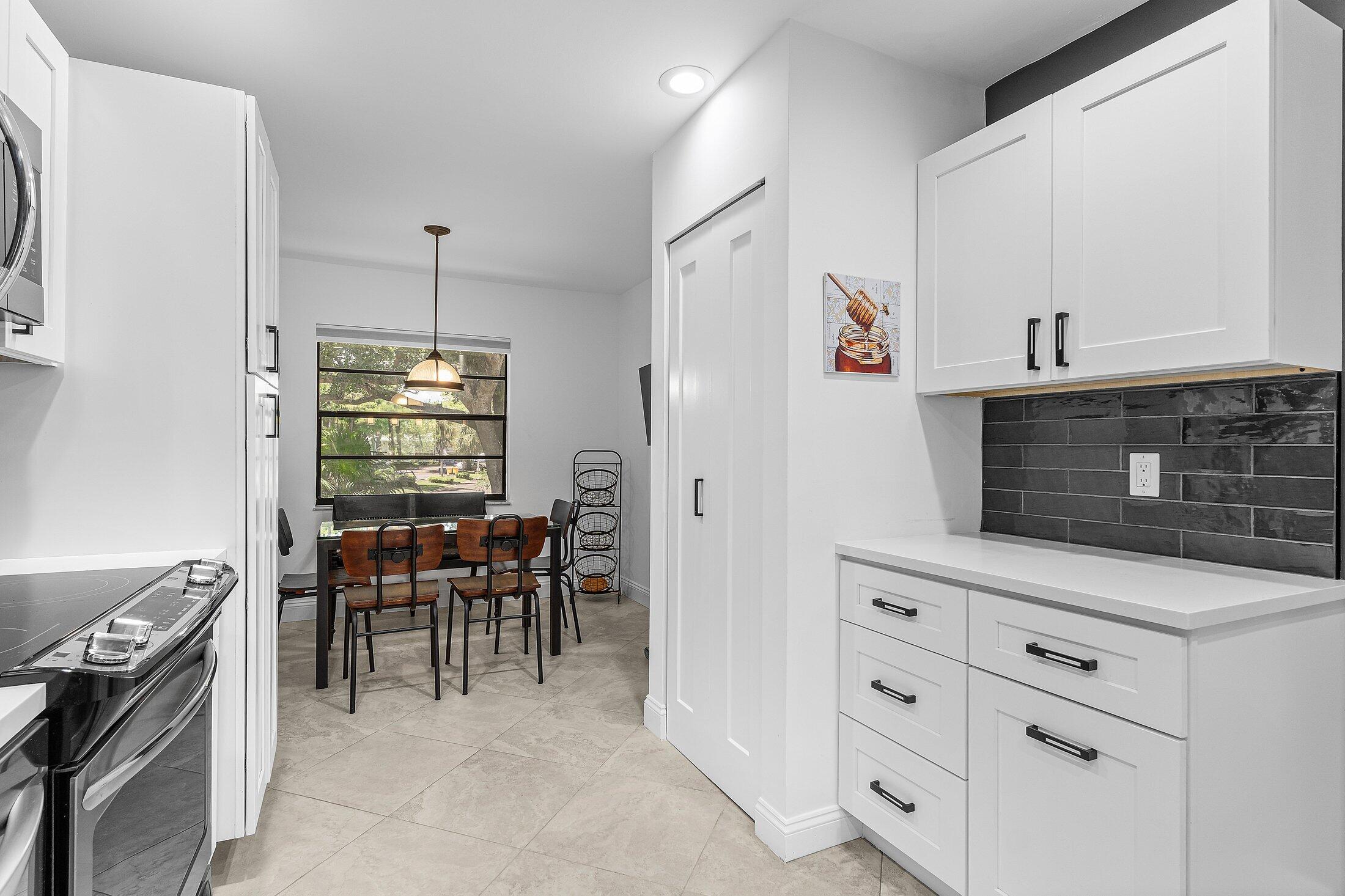 36 Westgate Lane, Unit D Boynton Beach, FL 33436 - Photo 12 of 51 a view of kitchen with sink microwave and cabinets