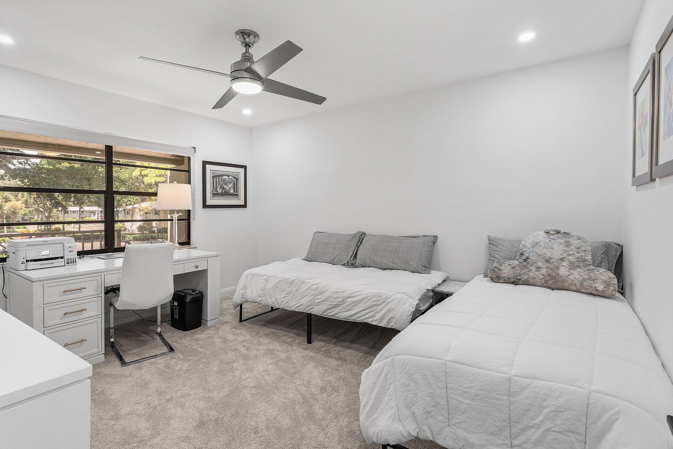 36 Westgate Lane, Unit D Boynton Beach, FL 33436 - Photo 19 of 51 a bed room with two bed and a large window