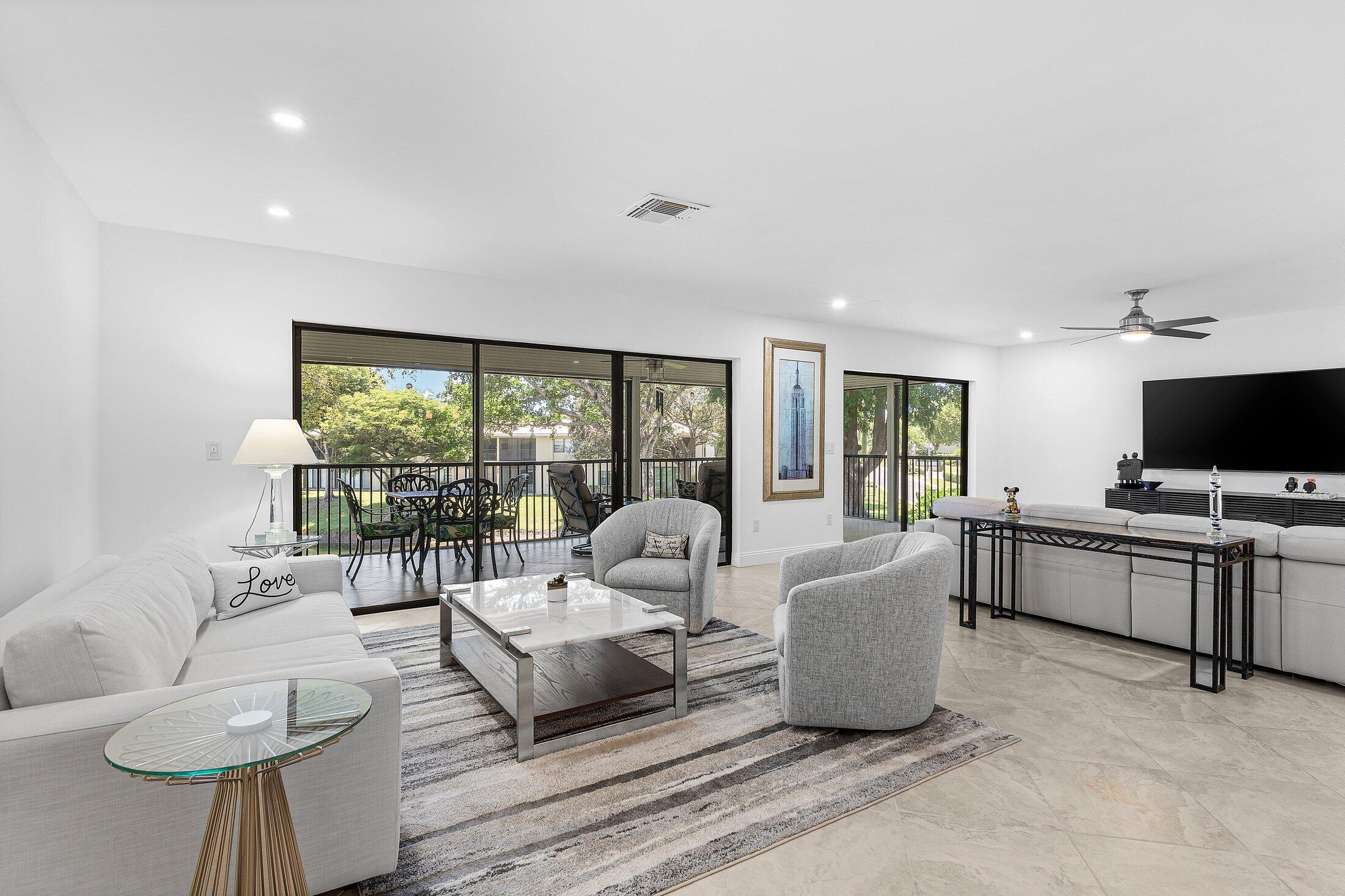 36 Westgate Lane, Unit D Boynton Beach, FL 33436 - Photo 2 of 51 a living room with furniture and a flat screen tv