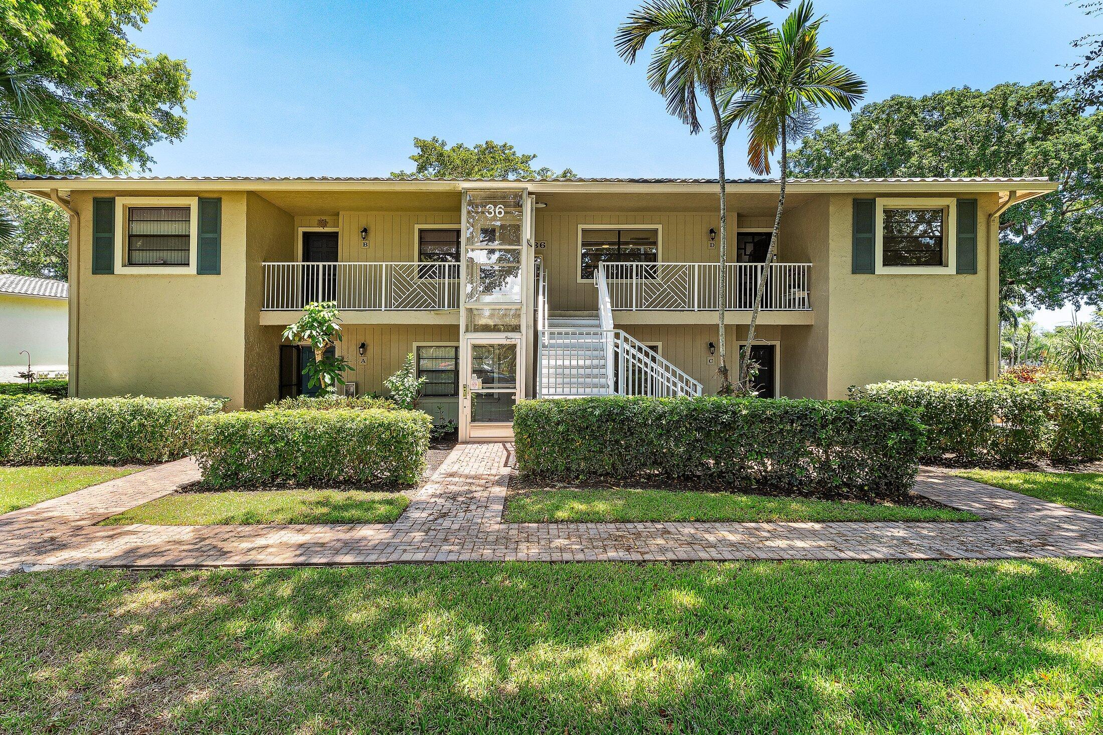 36 Westgate Lane, Unit D Boynton Beach, FL 33436 - Photo 29 of 51 a front view of a house with a yard and garage