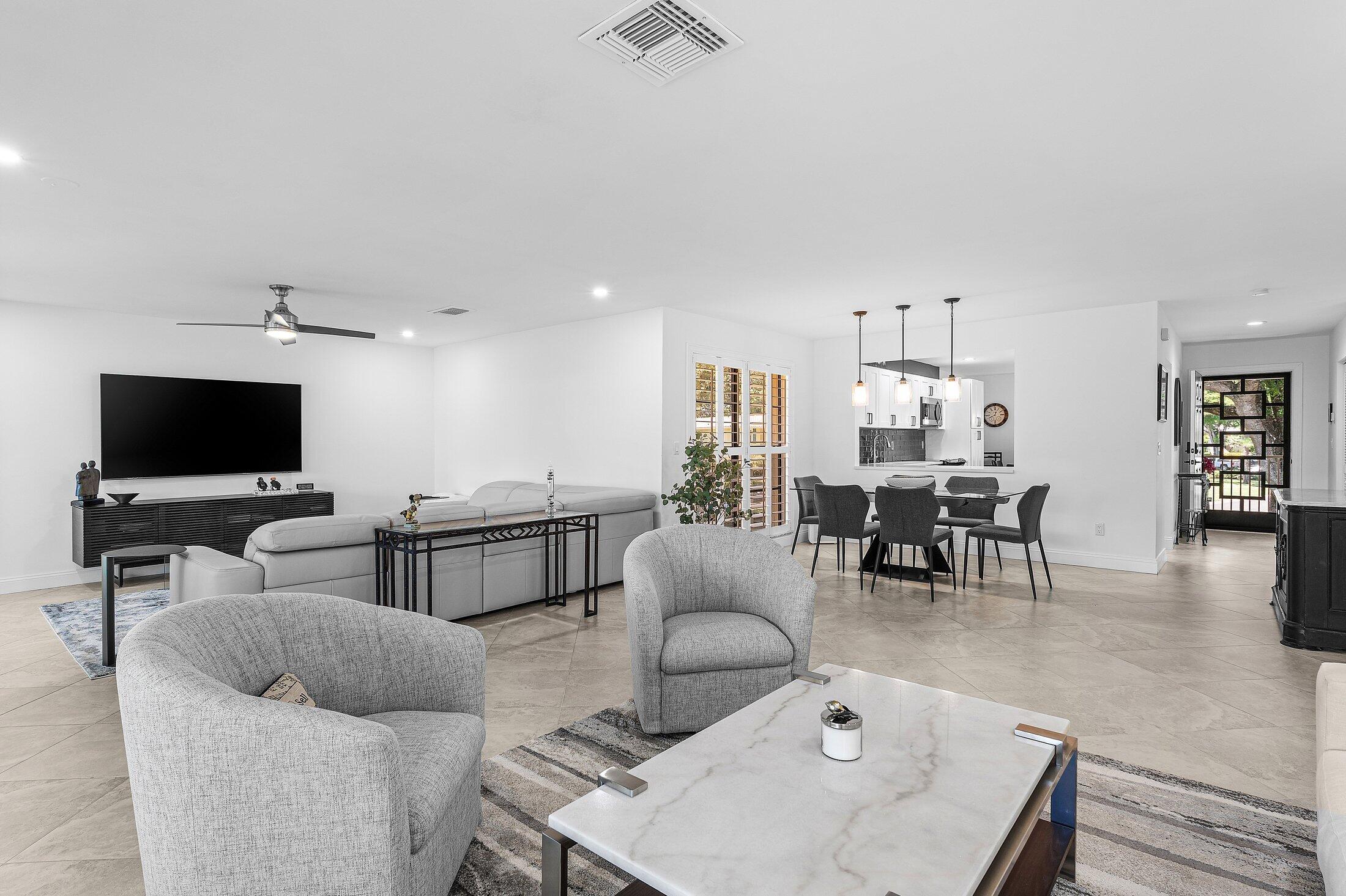 36 Westgate Lane, Unit D Boynton Beach, FL 33436 - Photo 3 of 51 a living room with furniture and a flat screen tv