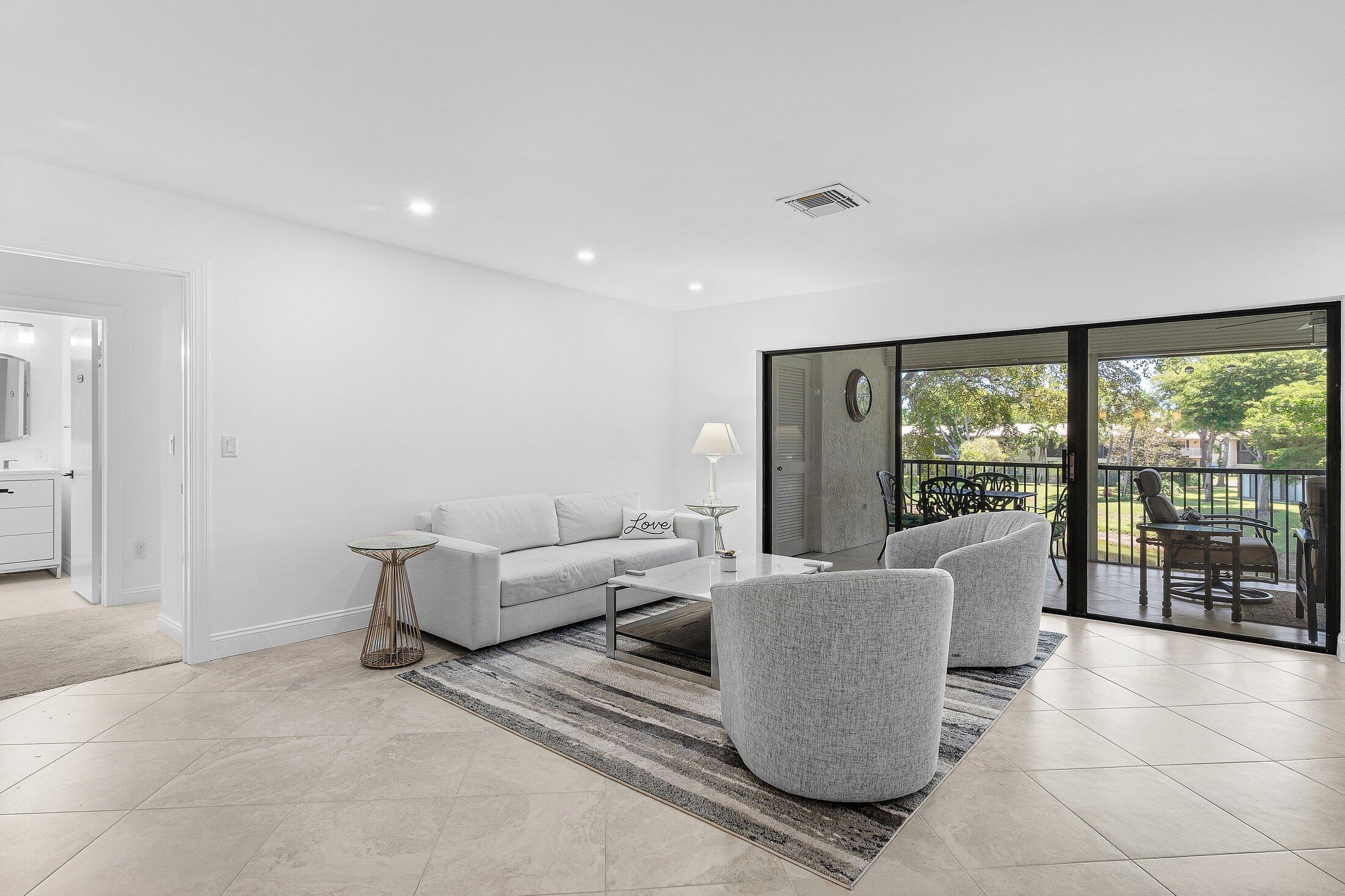 36 Westgate Lane, Unit D Boynton Beach, FL 33436 - Photo 4 of 51 a living room with furniture and large windows