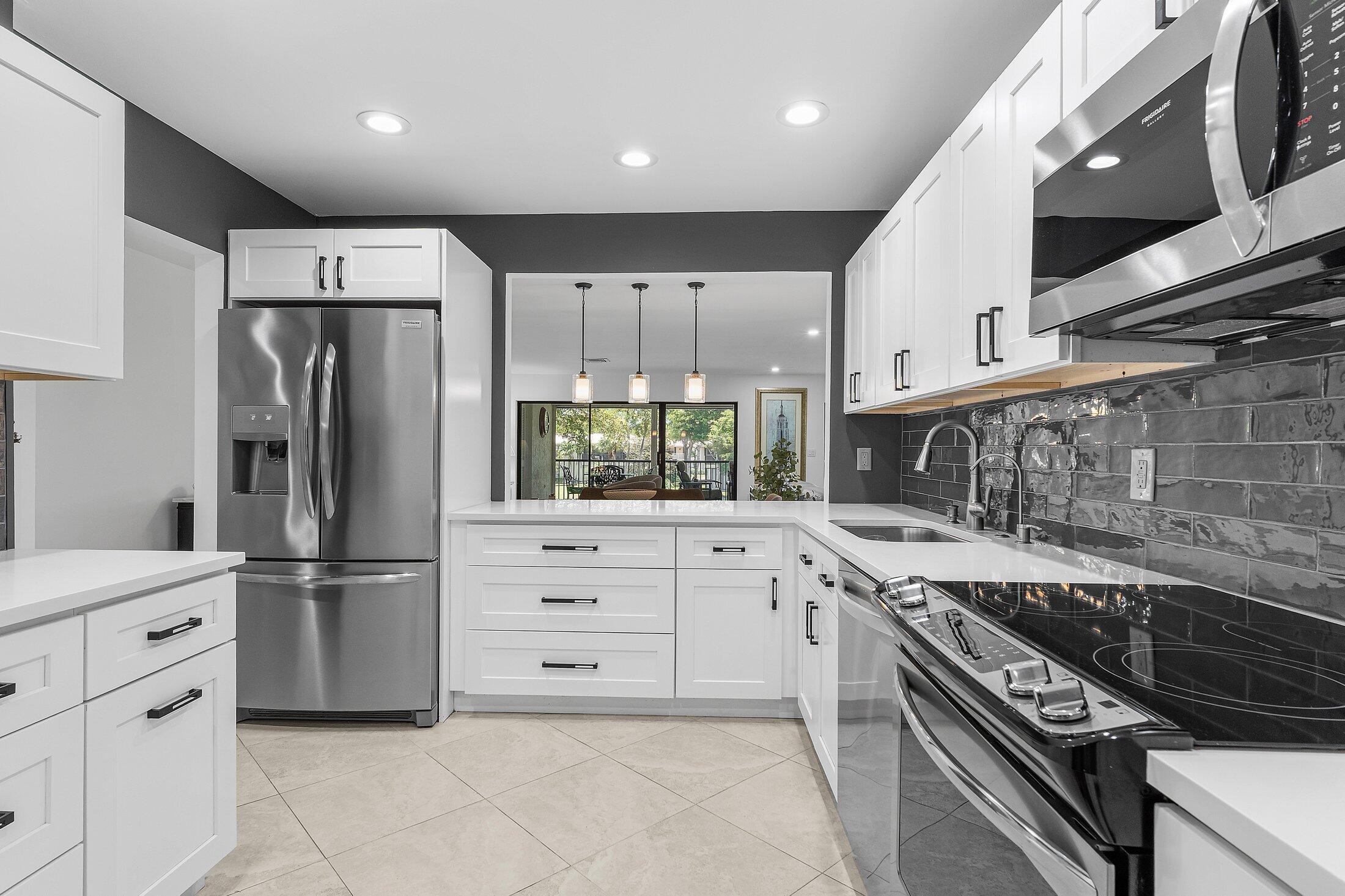 36 Westgate Lane, Unit D Boynton Beach, FL 33436 - Photo 10 of 51 a kitchen with stainless steel appliances a refrigerator sink and cabinets