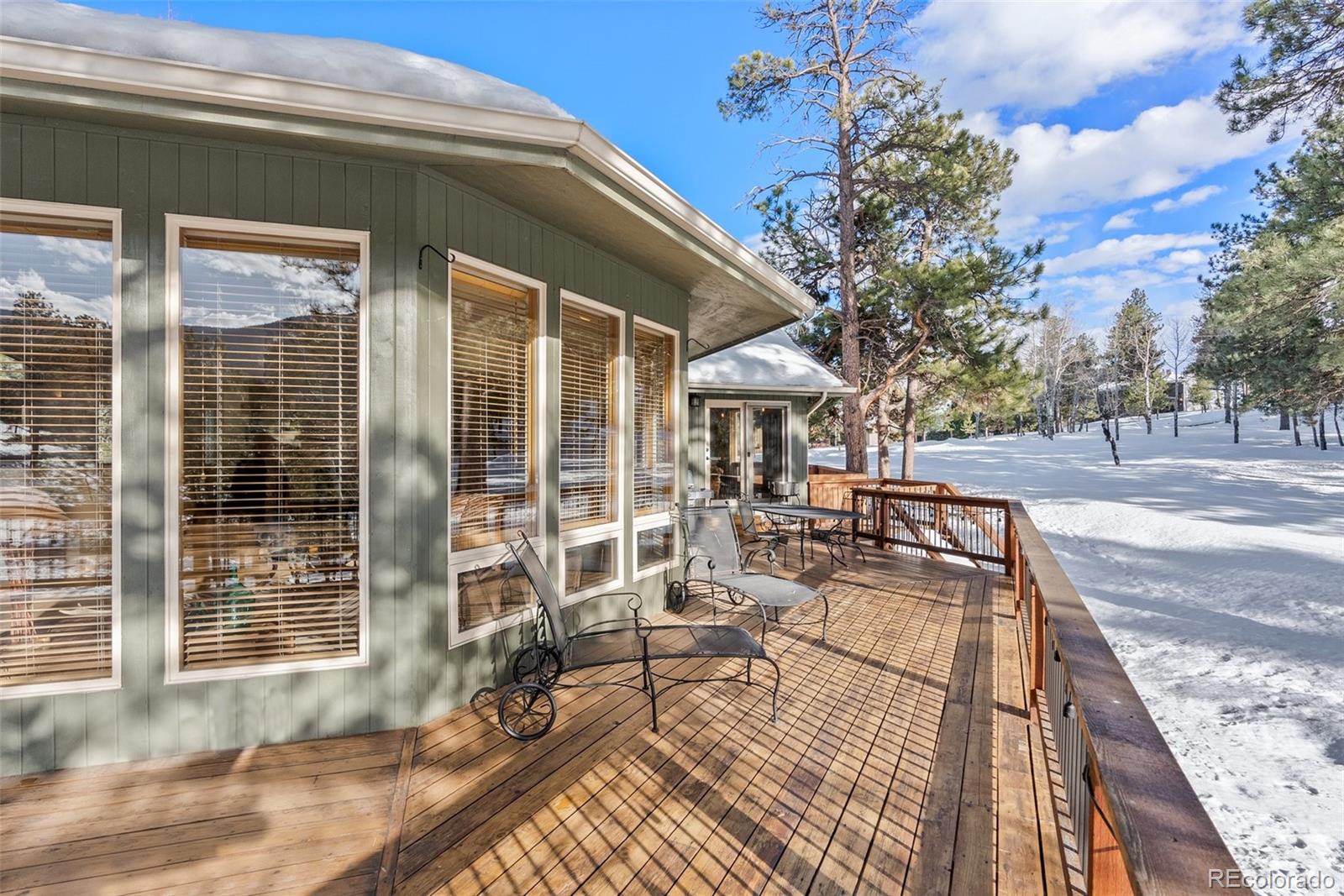 420 Stagecoach Boulevard Evergreen, CO 80439 - Photo 37 of 49 a view of a patio with couches and table and chairs with wooden floor and fence