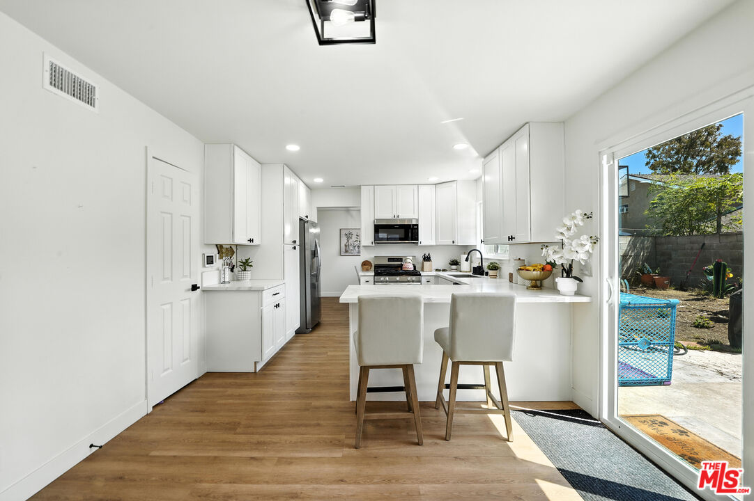 21312 Island Avenue Carson, CA 90745 - Photo 13 of 26 a kitchen with white cabinets and stainless steel appliances