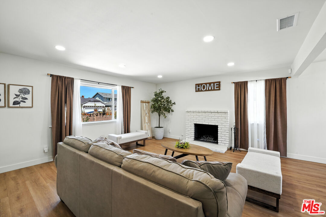 21312 Island Avenue Carson, CA 90745 - Photo 3 of 26 a living room with furniture a fireplace and wooden floor