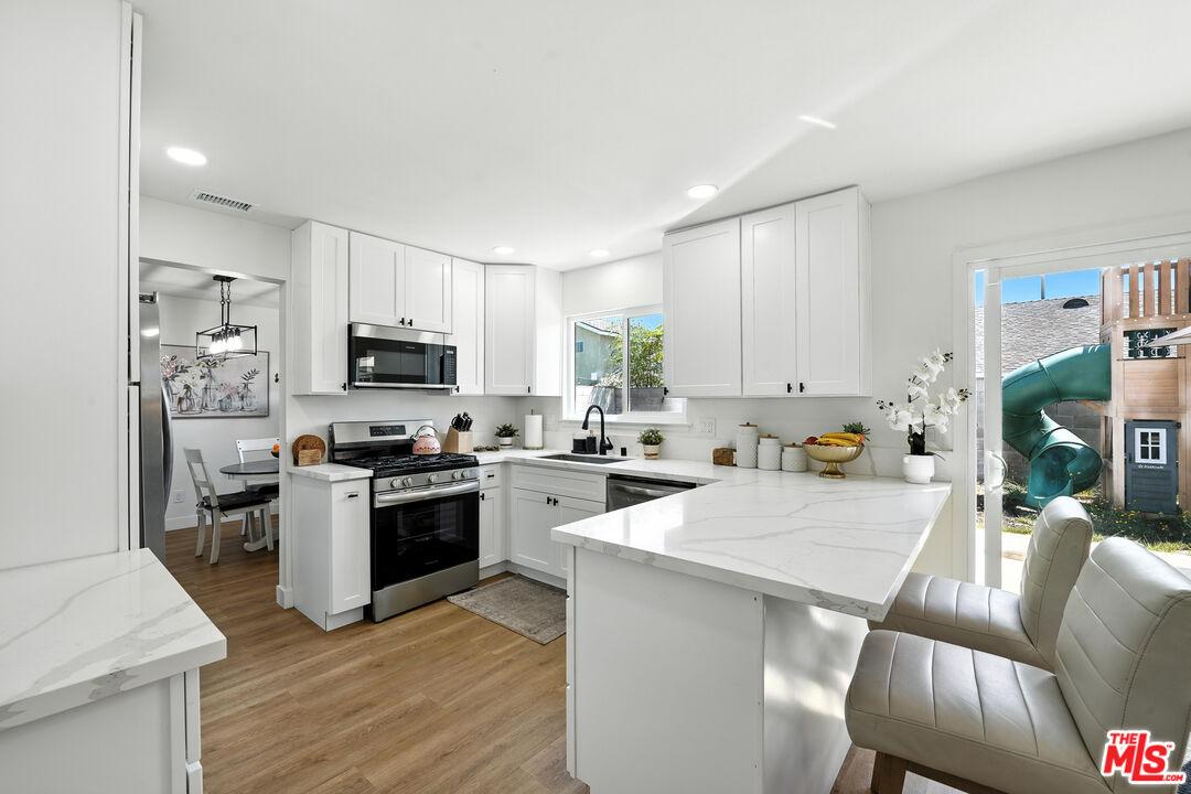 21312 Island Avenue Carson, CA 90745 - Photo 7 of 26 a kitchen with white cabinets and stainless steel appliances