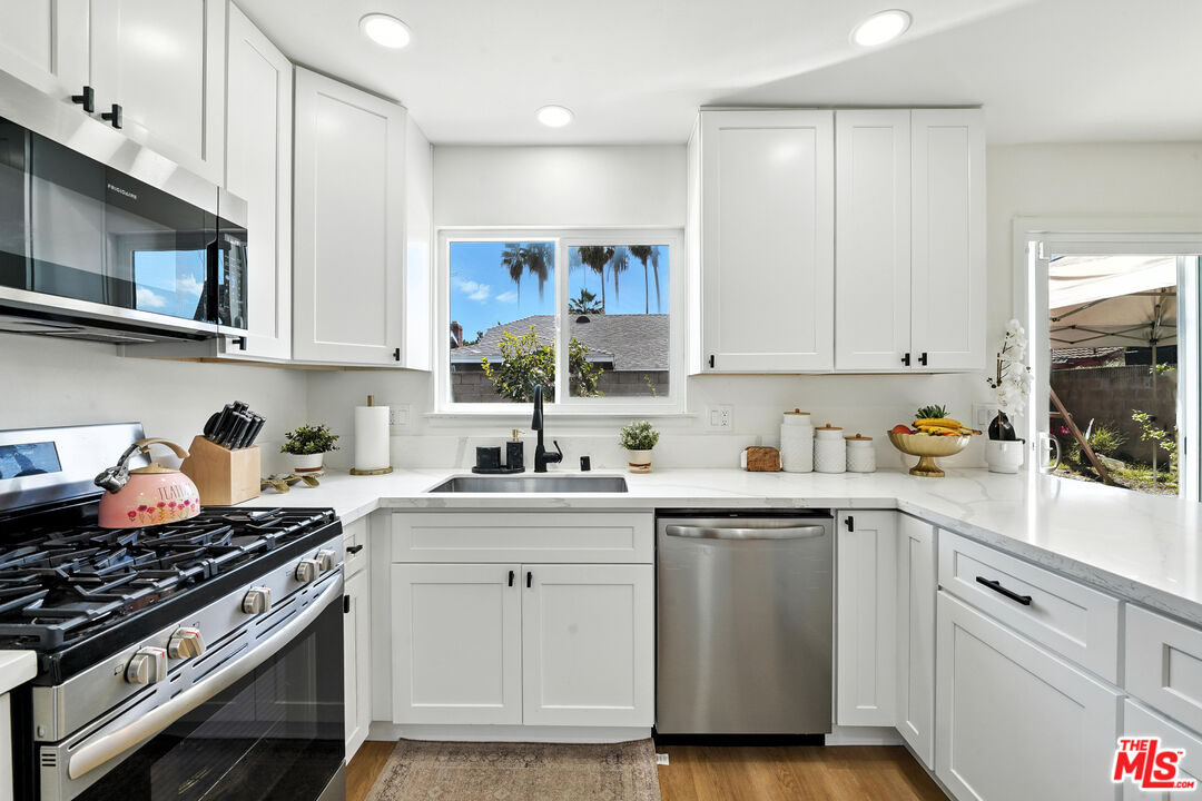 21312 Island Avenue Carson, CA 90745 - Photo 8 of 26 a kitchen with stainless steel appliances granite countertop a sink stove and cabinets