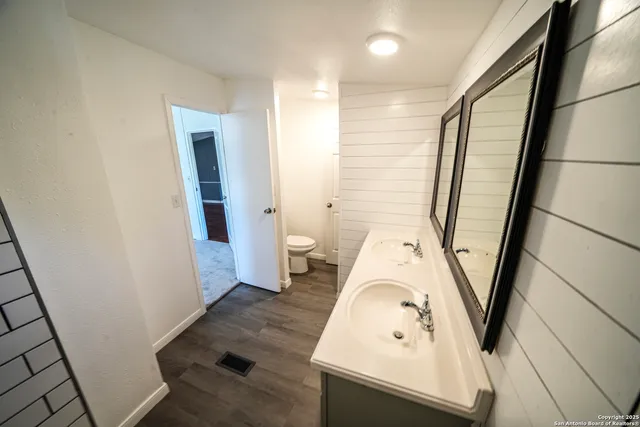 a view of a livingroom with wooden floor and a stairs