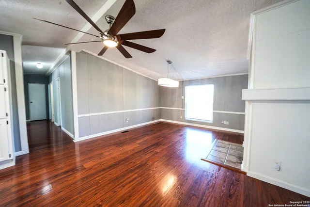 a view of empty room with wooden floor