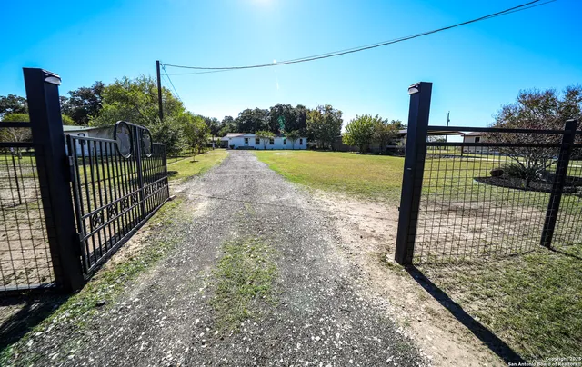 a view of a yard with wooden fence