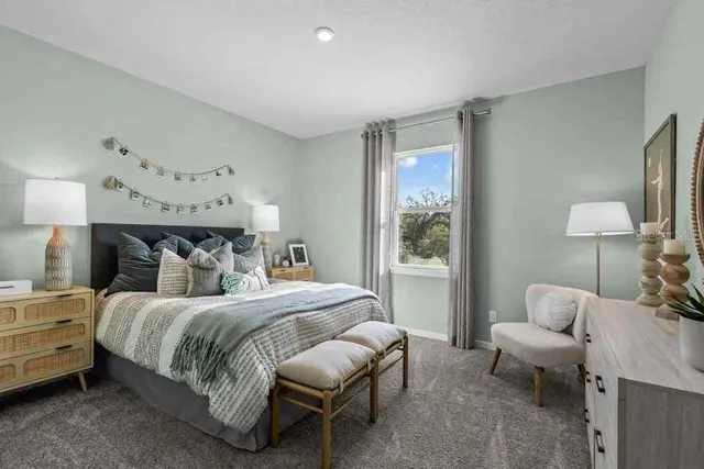 a bedroom with a large bed and a chandelier