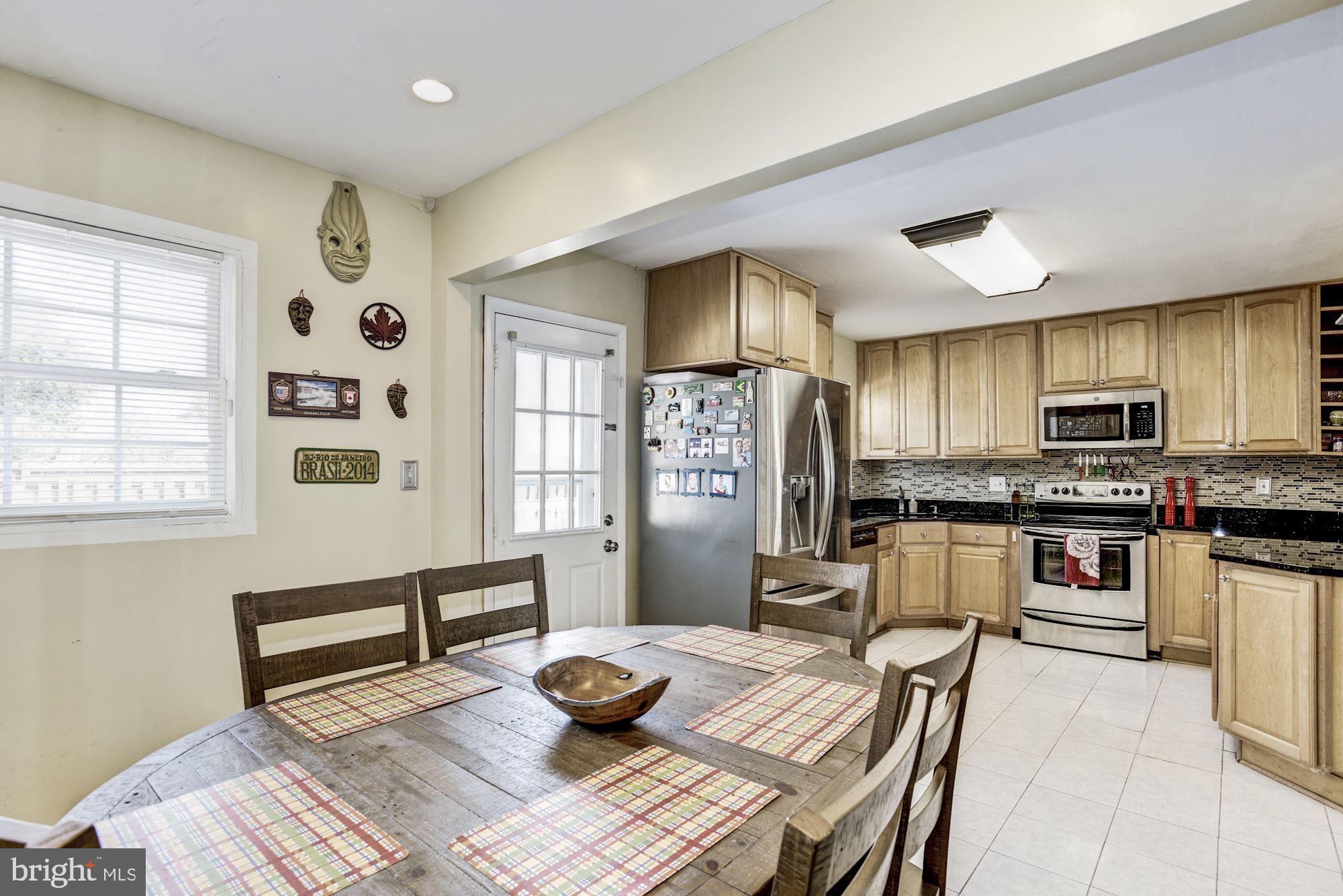 6708 Cimarron Street Springfield, VA 22150 - Photo 22 of 46 a living room with stainless steel appliances furniture a dining table and kitchen view