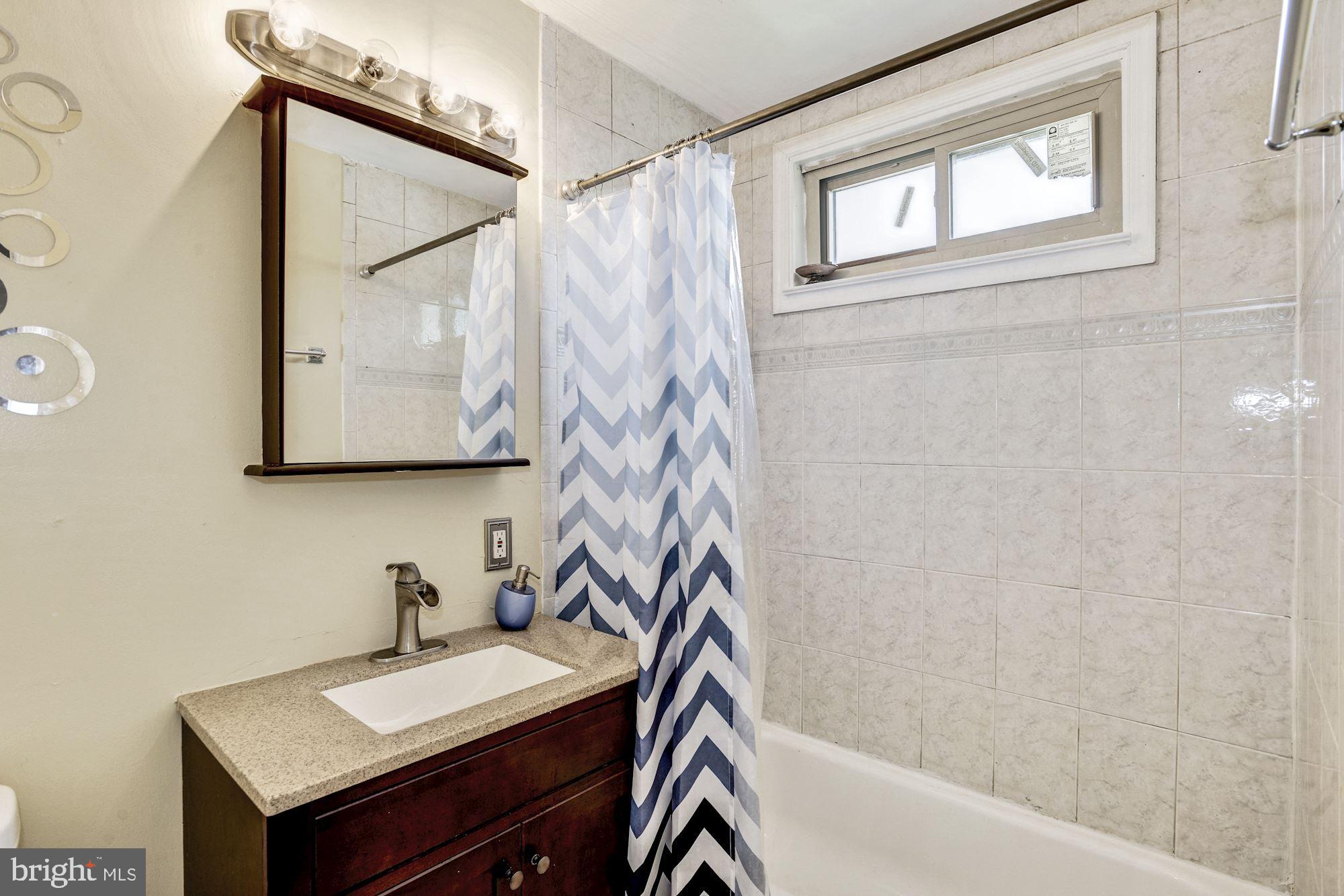 6708 Cimarron Street Springfield, VA 22150 - Photo 8 of 46 a bathroom with a sink a mirror and a shower