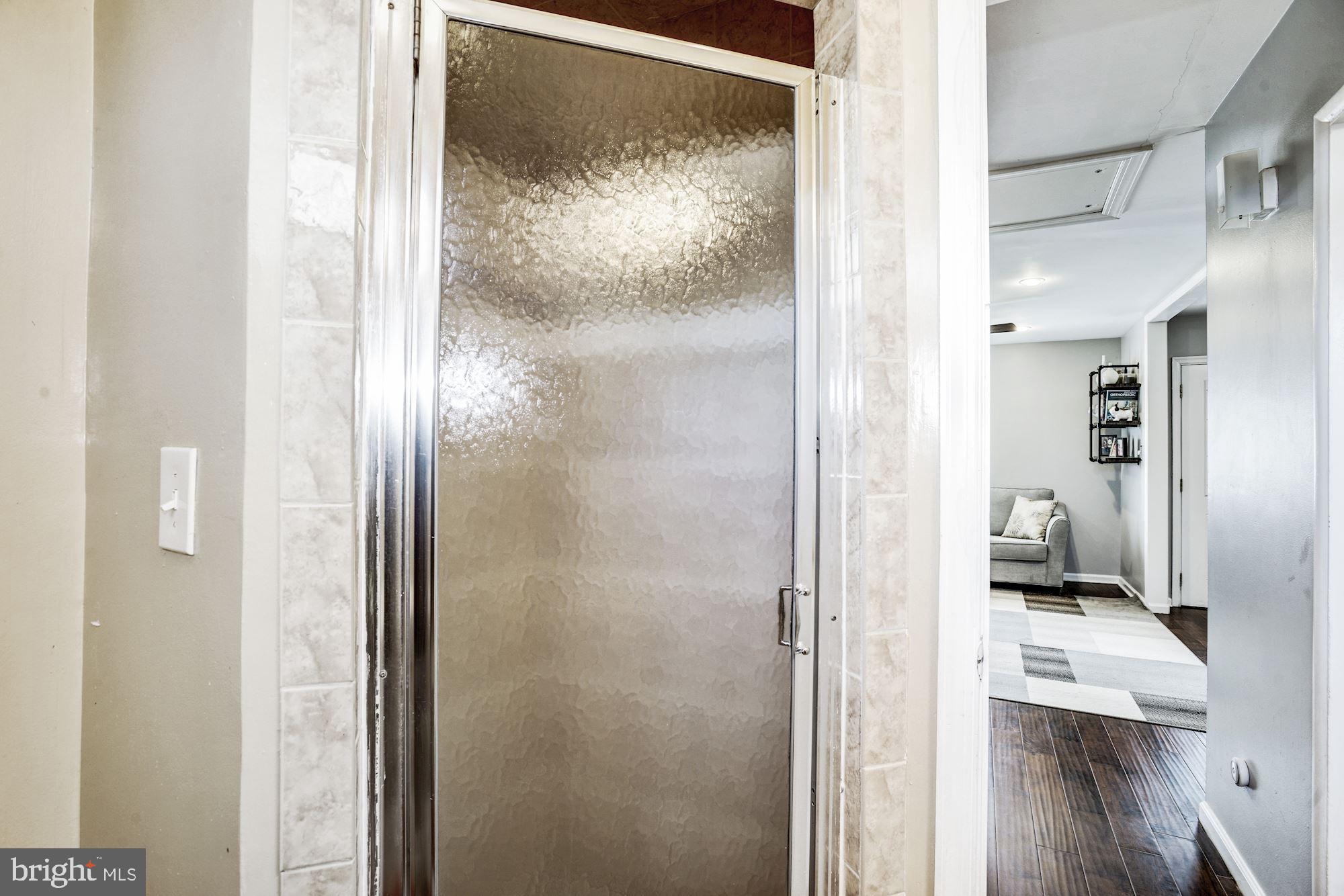 6708 Cimarron Street Springfield, VA 22150 - Photo 10 of 46 a bathroom with a glass shower door