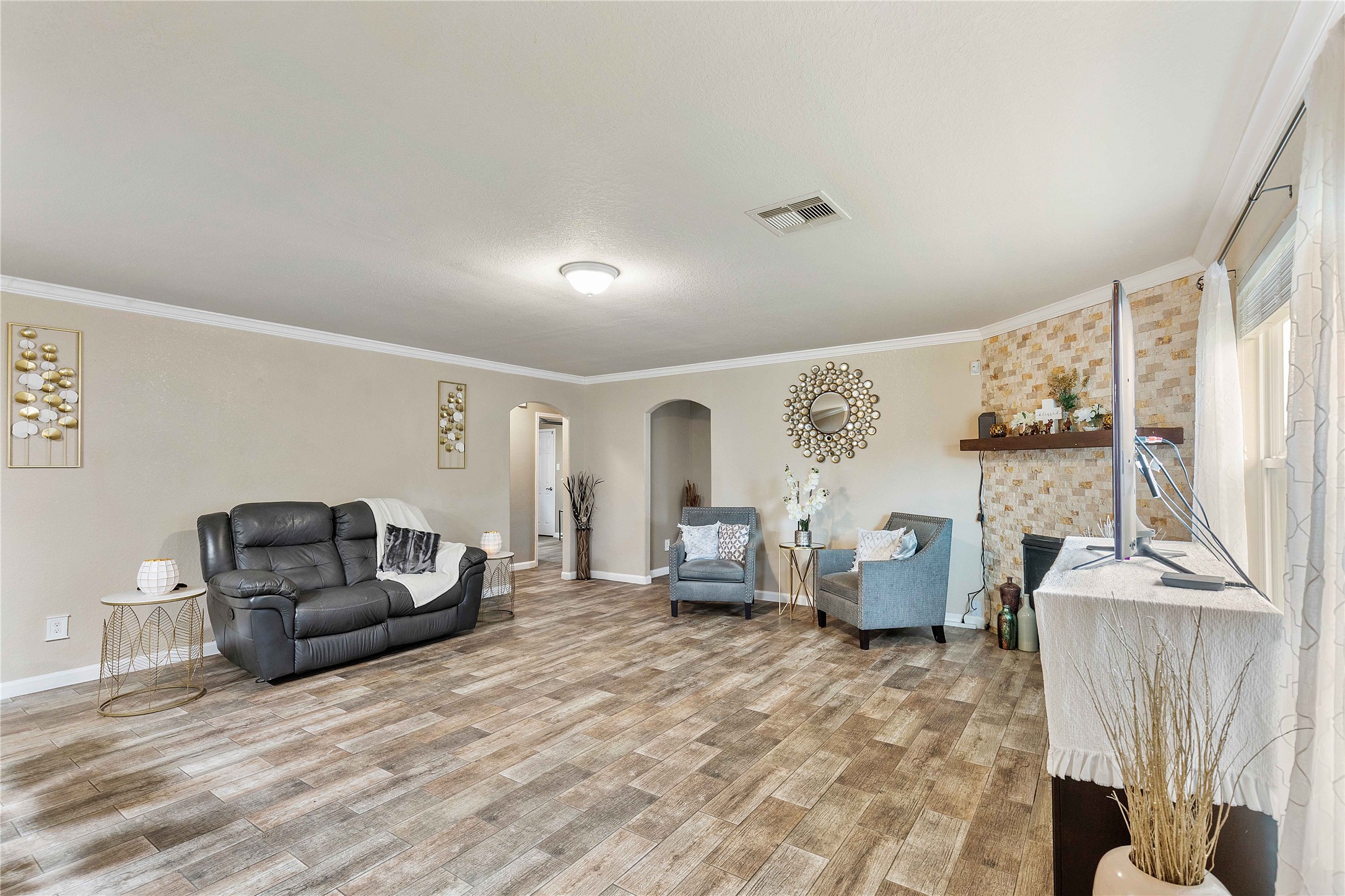 11031 Bauer Elm Street Houston, TX 77044 - Photo 14 of 33 Spacious living room with wood-style flooring, neutral walls, and ample natural light. Features a cozy fireplace, modern decor, and comfortable seating. Perfect for relaxation and entertaining.