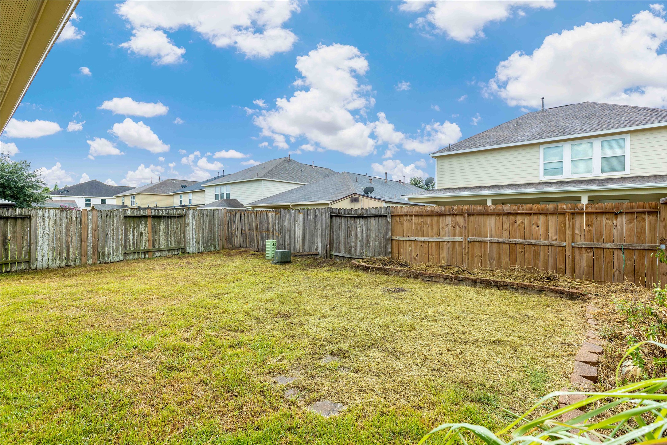 11031 Bauer Elm Street Houston, TX 77044 - Photo 29 of 33 This backyard features a spacious, fenced area with a mix of wooden fence styles. It offers a level grassy space ideal for outdoor activities, with neighboring homes visible over the fence. Perfect for families or pets.