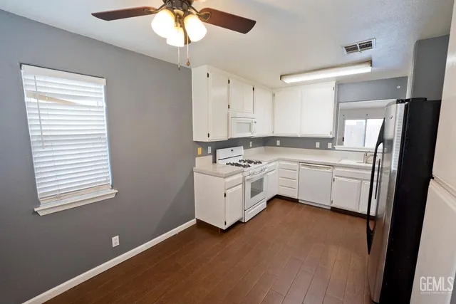 a kitchen with stainless steel appliances a white stove top oven sink and window